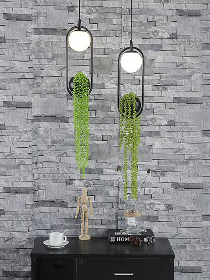 Viridia Glow | Hängelampe aus schwarzem Metall mit Milchglas und Deko-Pflanzen